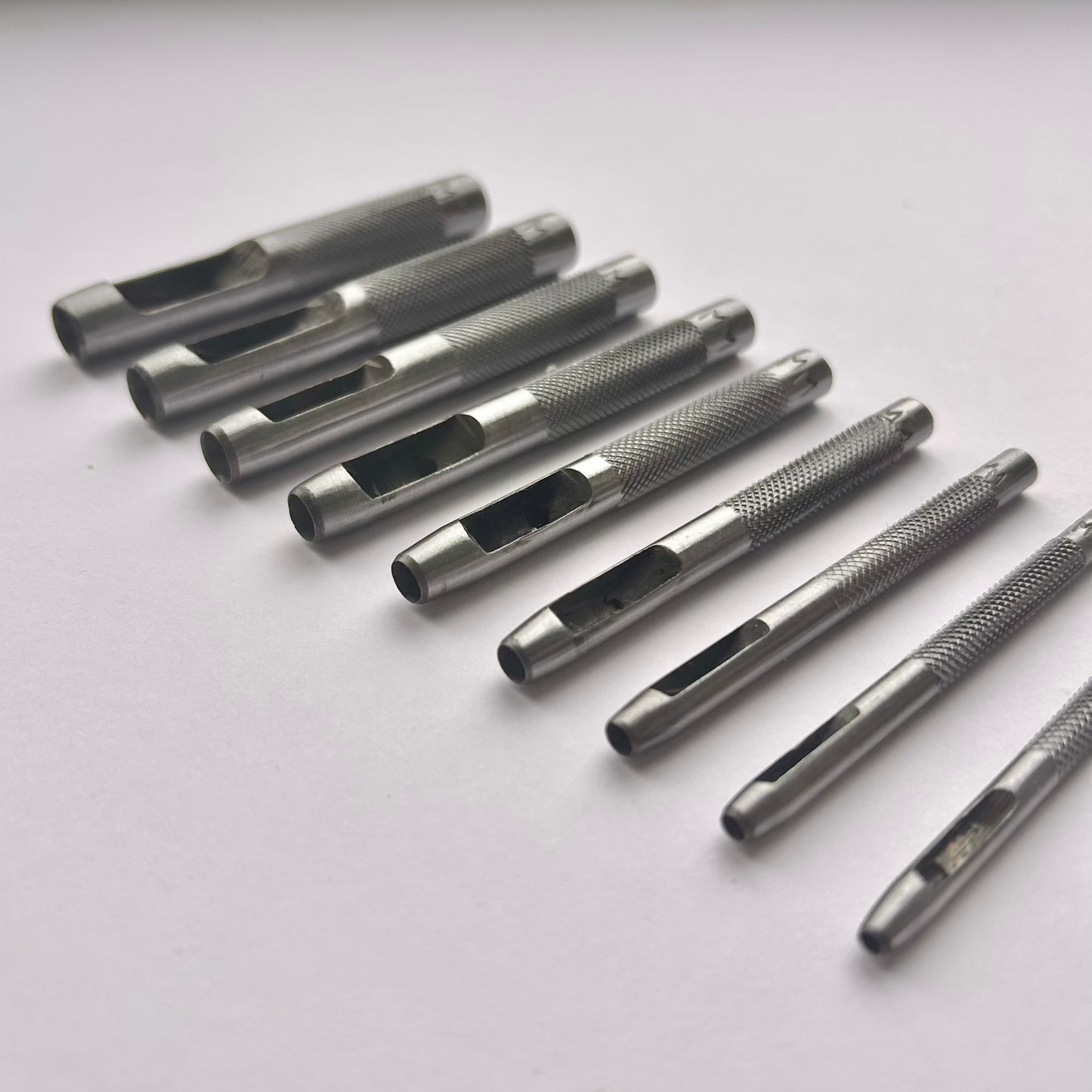 Set of metal leather drive punch tools on a grey background