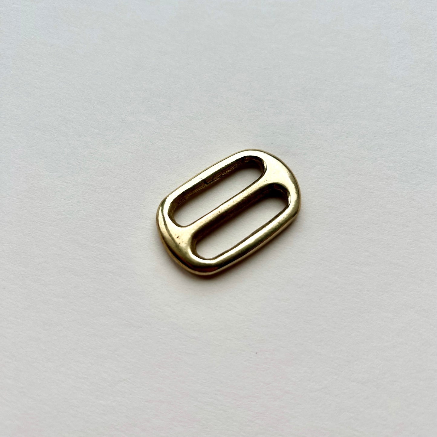 Gold brass metal belt slide on a white background