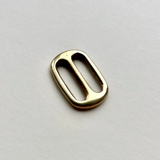 Gold brass metal belt slide on a white background