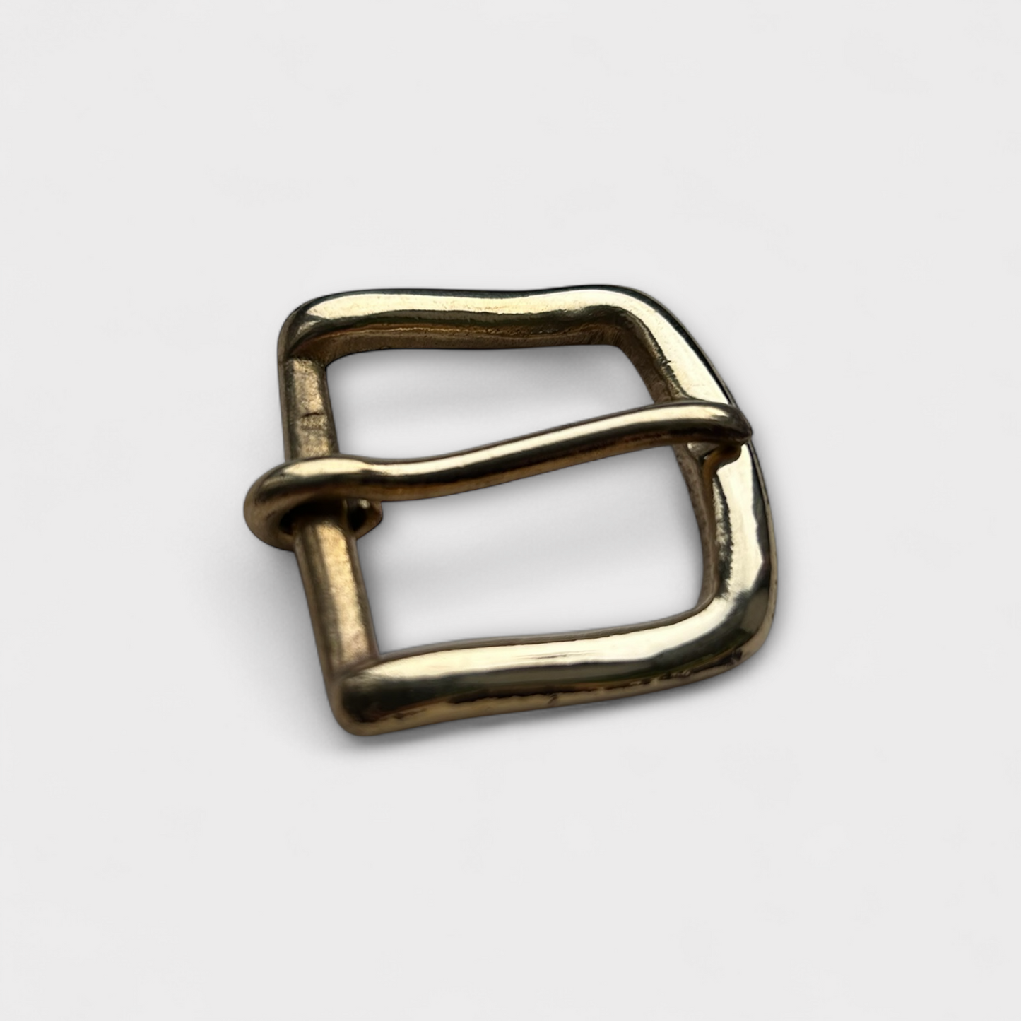 Gold metal buckle on a light gray background