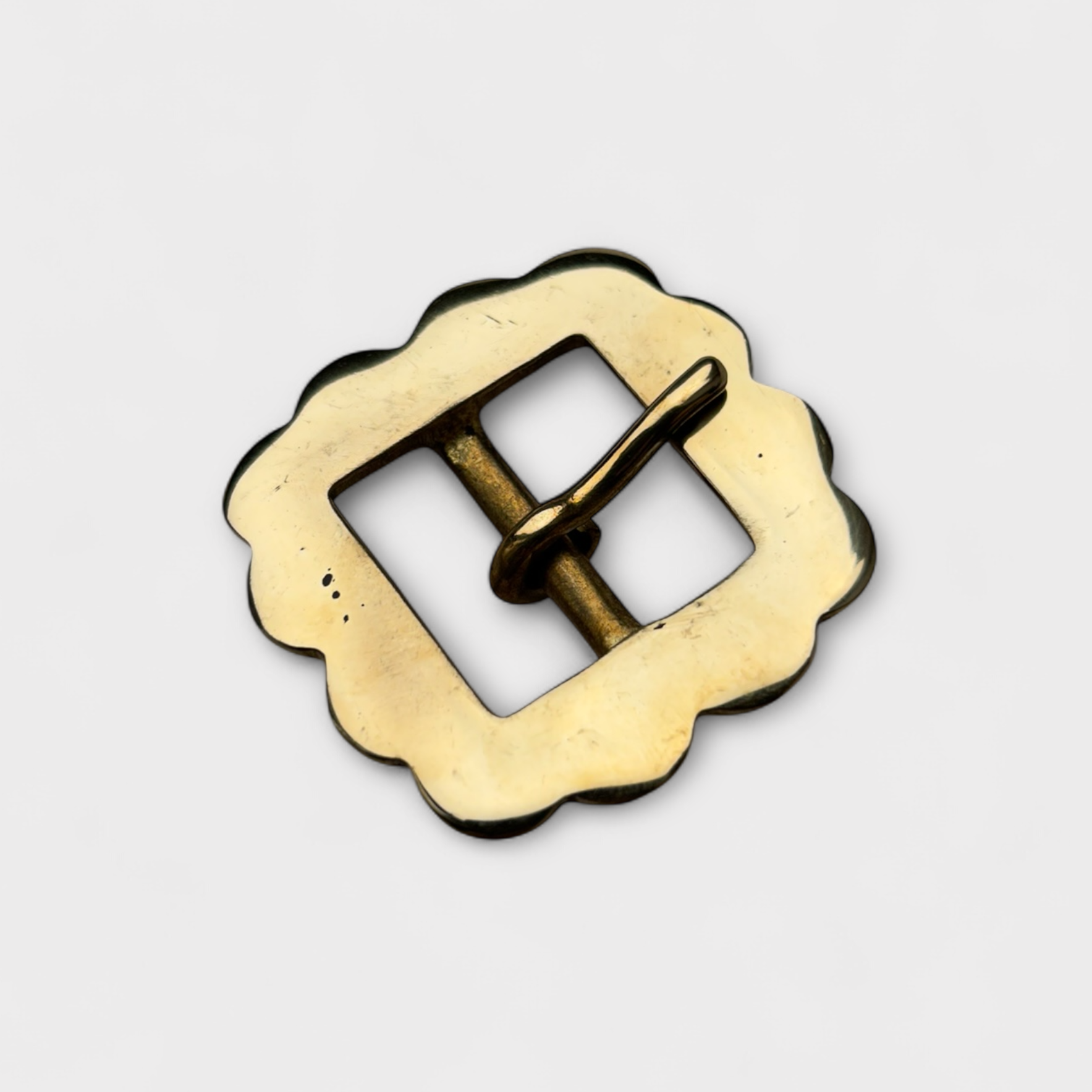 Gold metal buckle on a light gray background