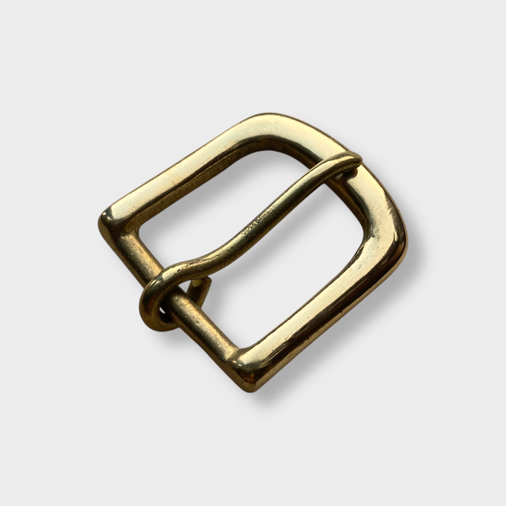 Brass buckle made in the UK on grey coloured background