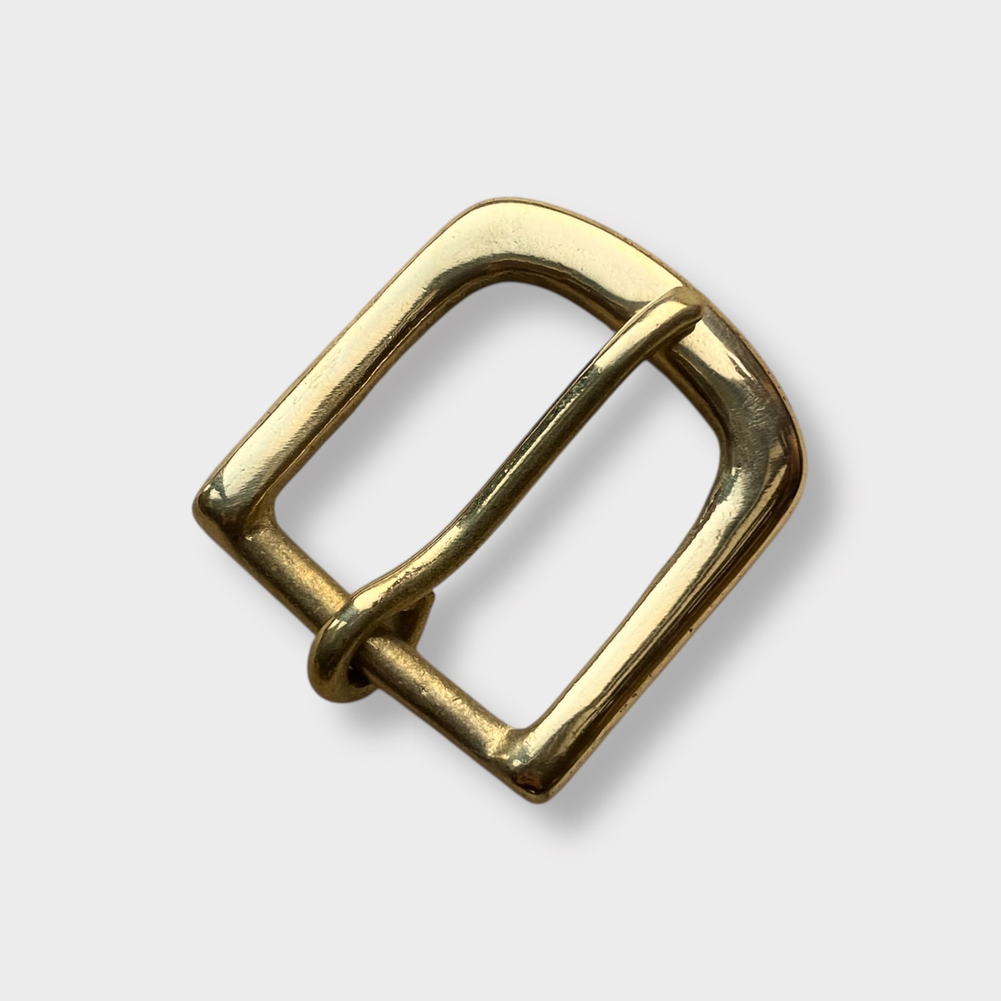 Brass buckle in West End style made in the UK on grey coloured background