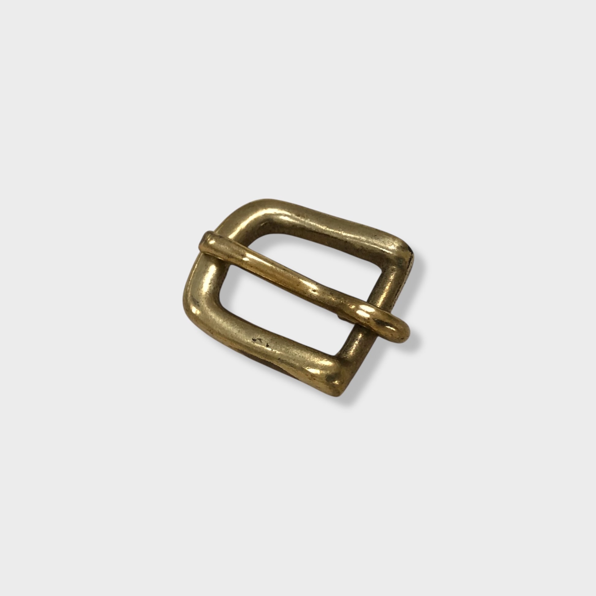 Brass buckle made in the UK on grey coloured background