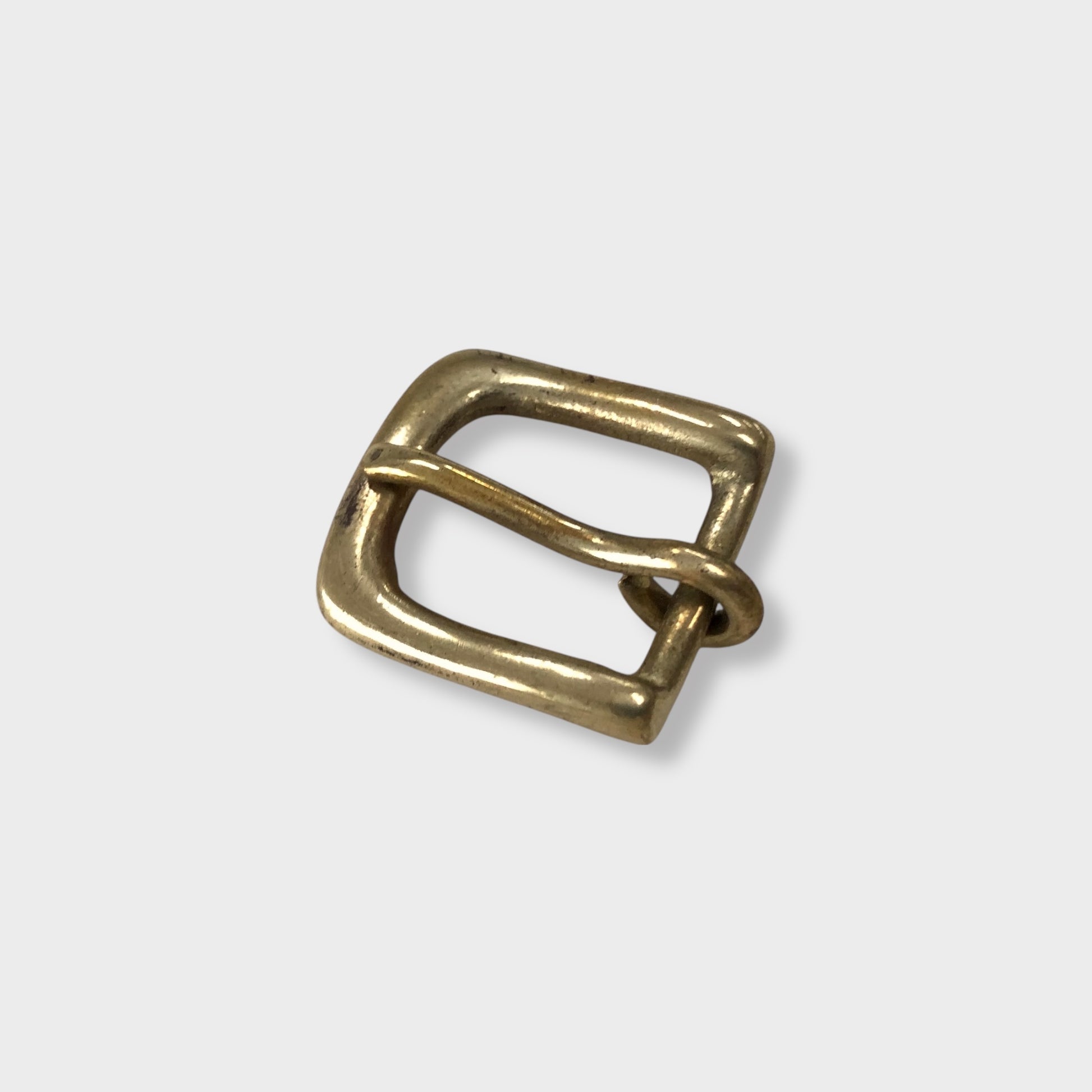 Brass buckle made in the UK on grey coloured background