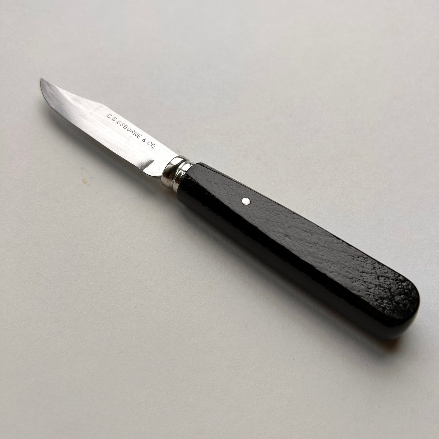 Knife with a black handle on a gray background