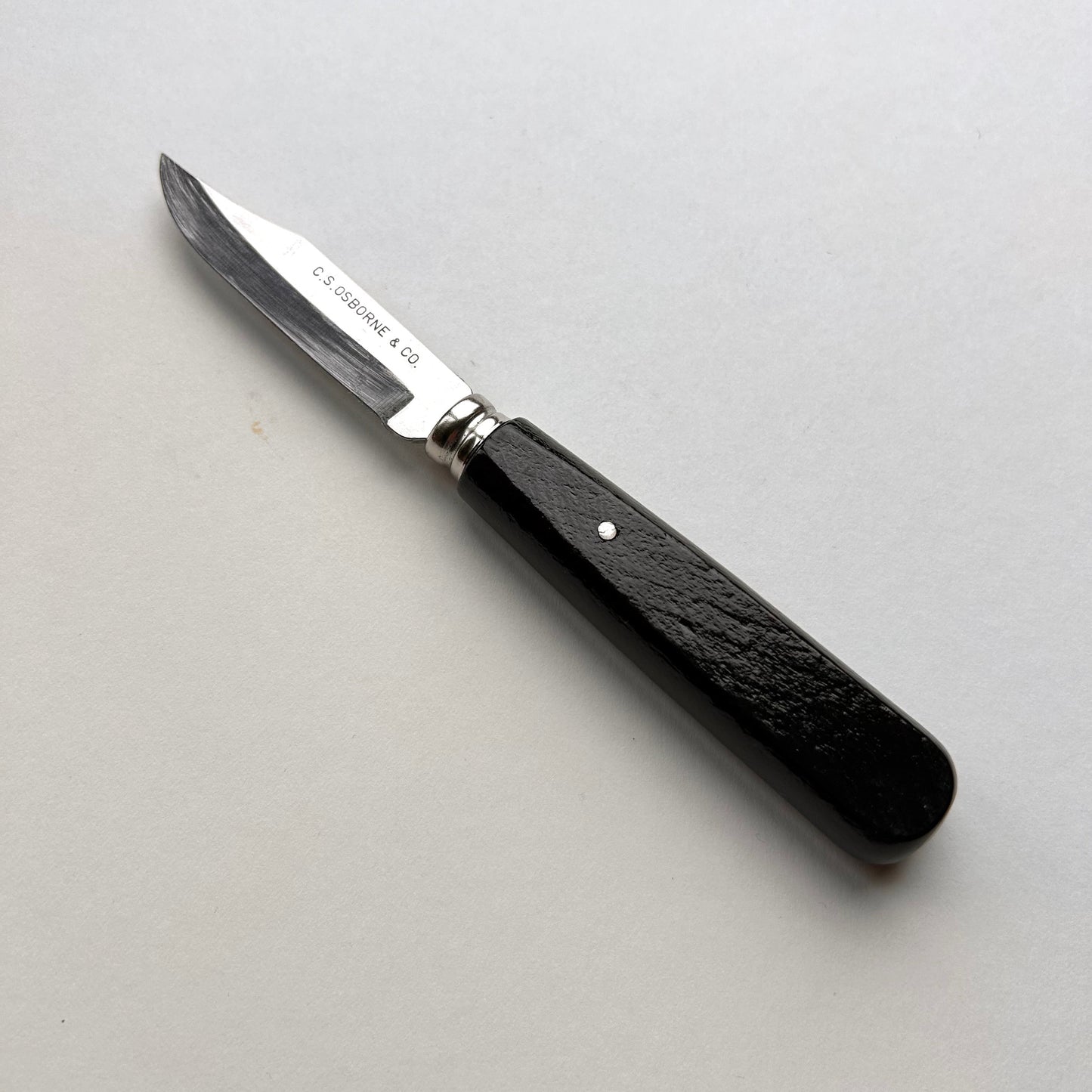 Knife with a black handle on a gray background