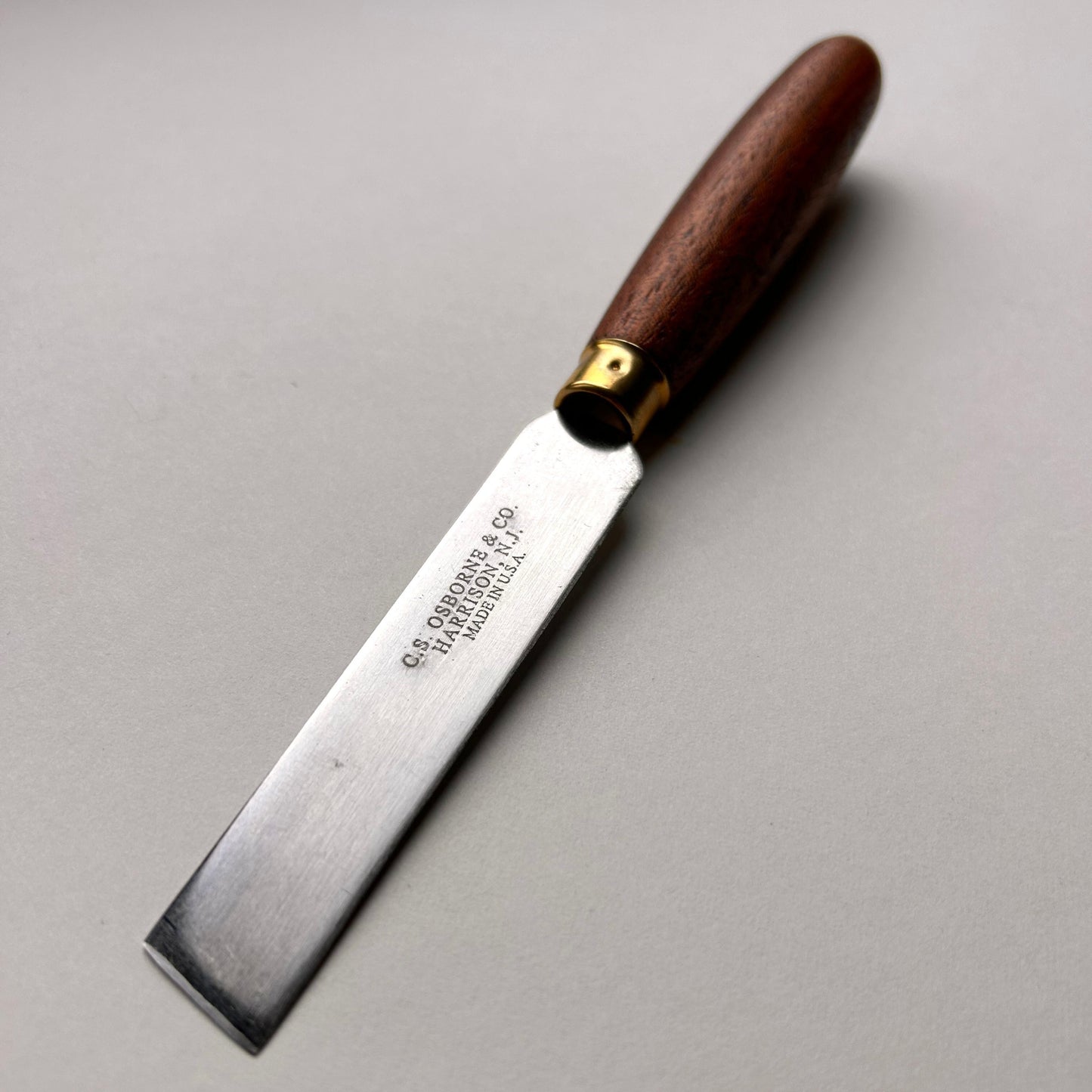 Woodworking chisel with a wooden handle on a gray background