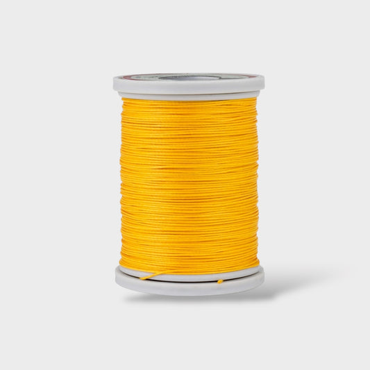 Spool of yellow thread on a white background