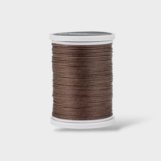 Spool of brown thread on a white background