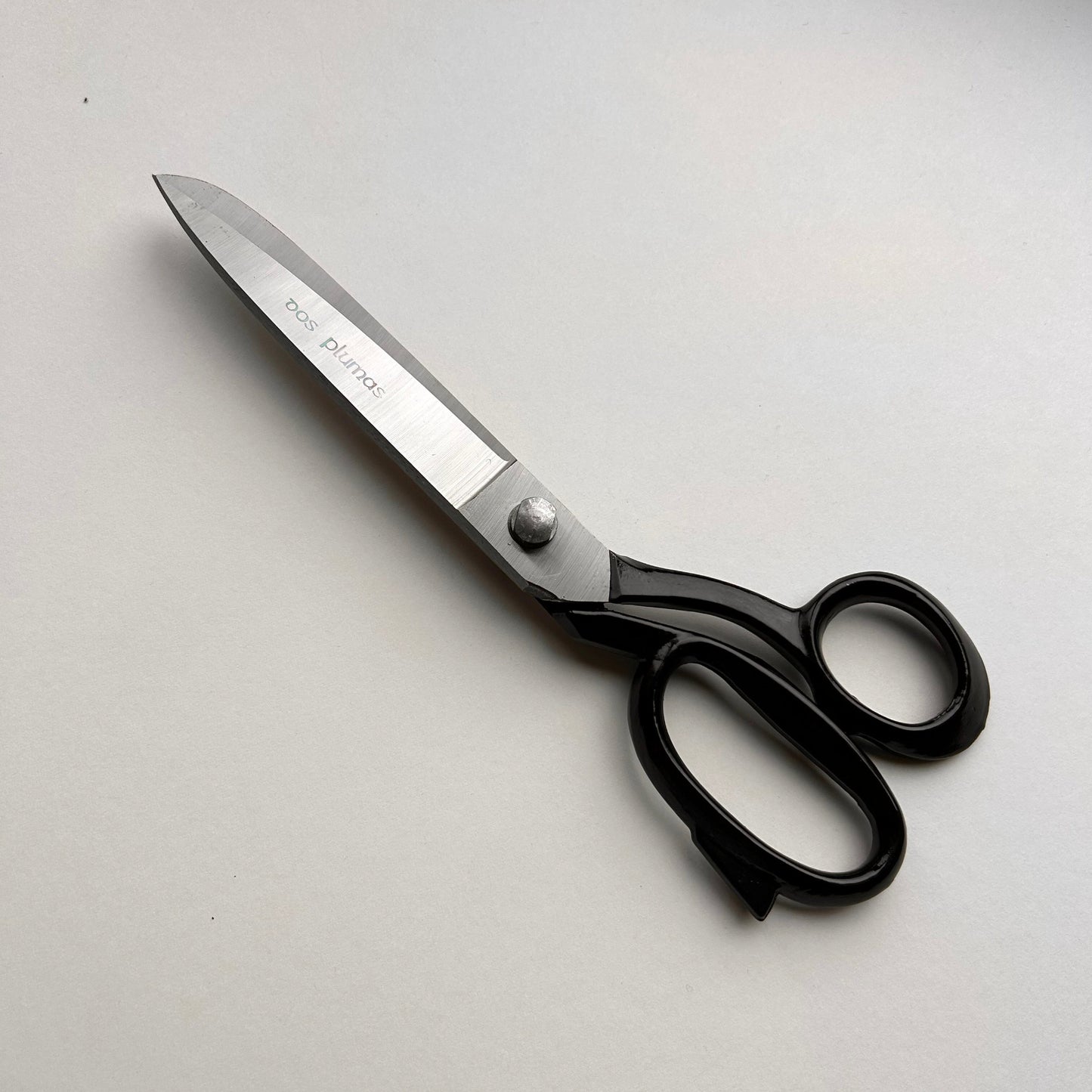 Pair of leather scissors with black handles on a white background