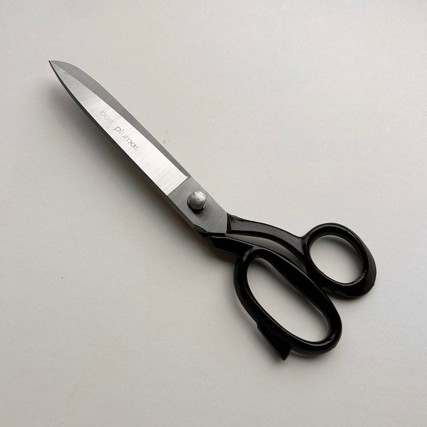Pair of leather scissors with black handles on a white background