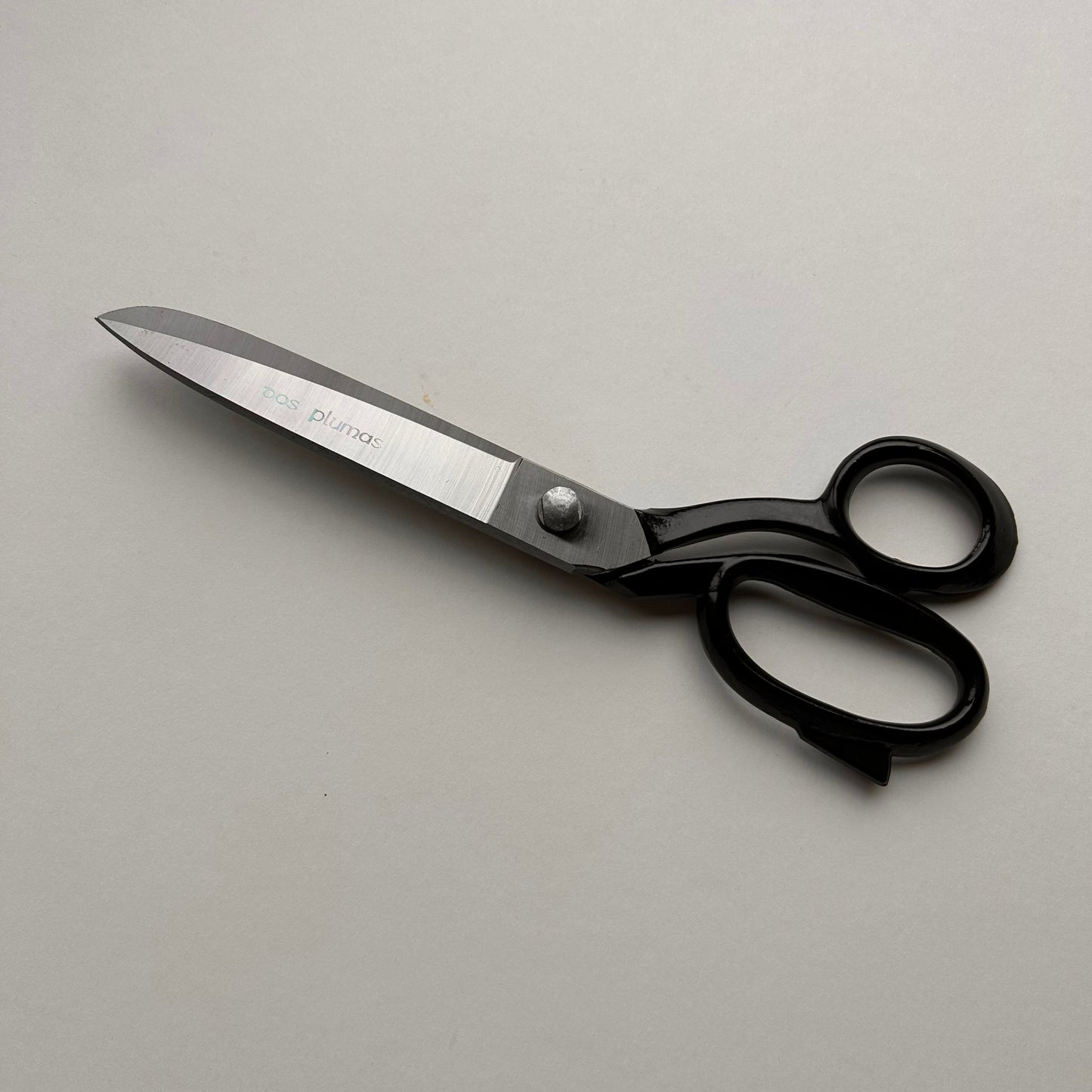 Pair of leather scissors with black handles on a white background