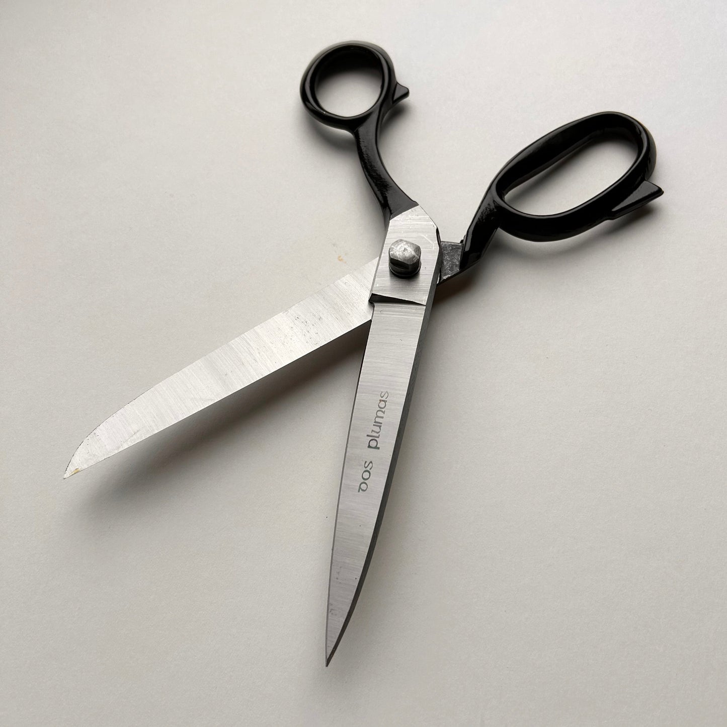 Pair of leather scissors with black handles on a white background