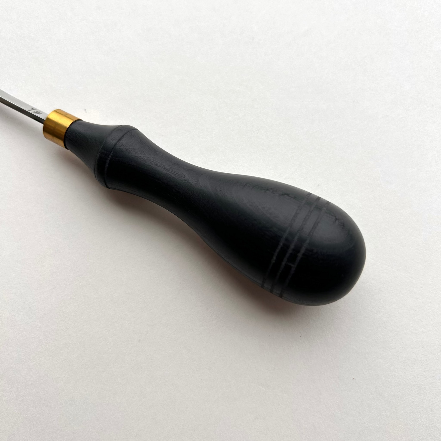 Ebony-handled leather edge beveller on a white background