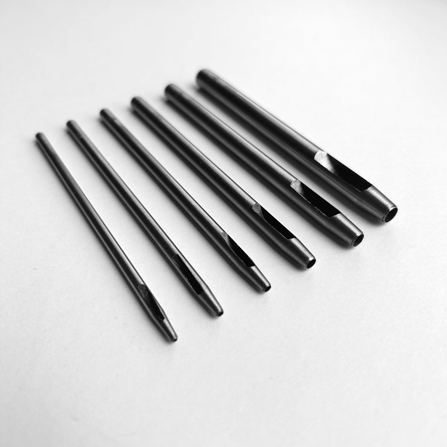 Set of six leather hole punch tools on a white background