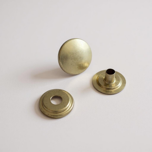 Gold popper snap fasteners on white background