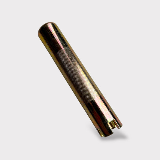 Gold-colored cylindrical metal leather embossing tool on a light grey background