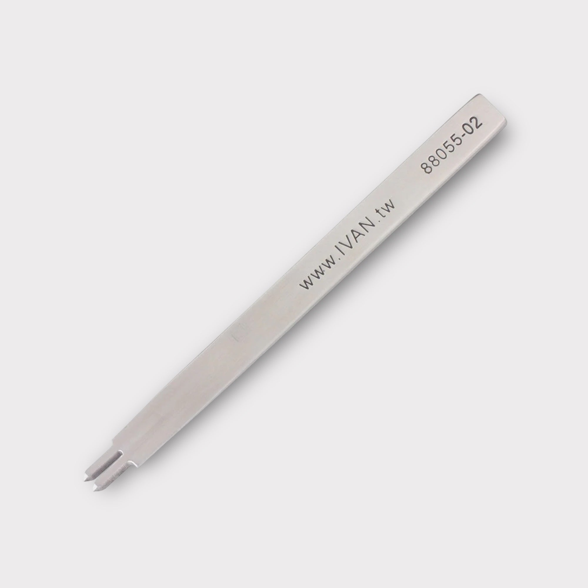 Stainless steel leather stitching punch with engraved IVAN text on a light grey background