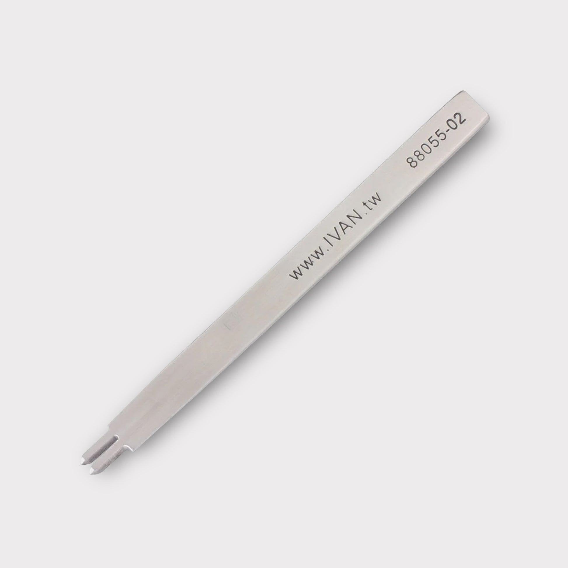 Stainless steel leather stitching punch with engraved IVAN text on a light grey background