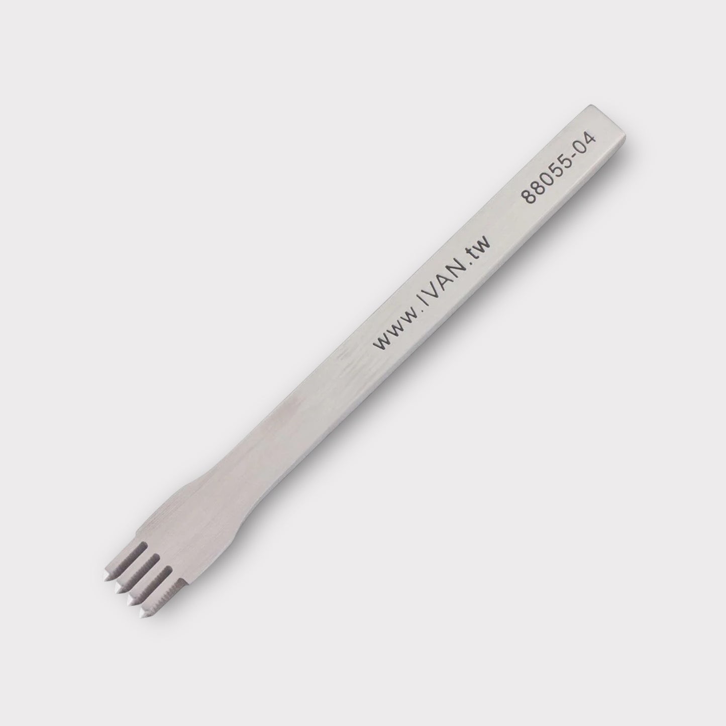 Stainless steel leather stitching punch with engraved IVAN text on a light grey background