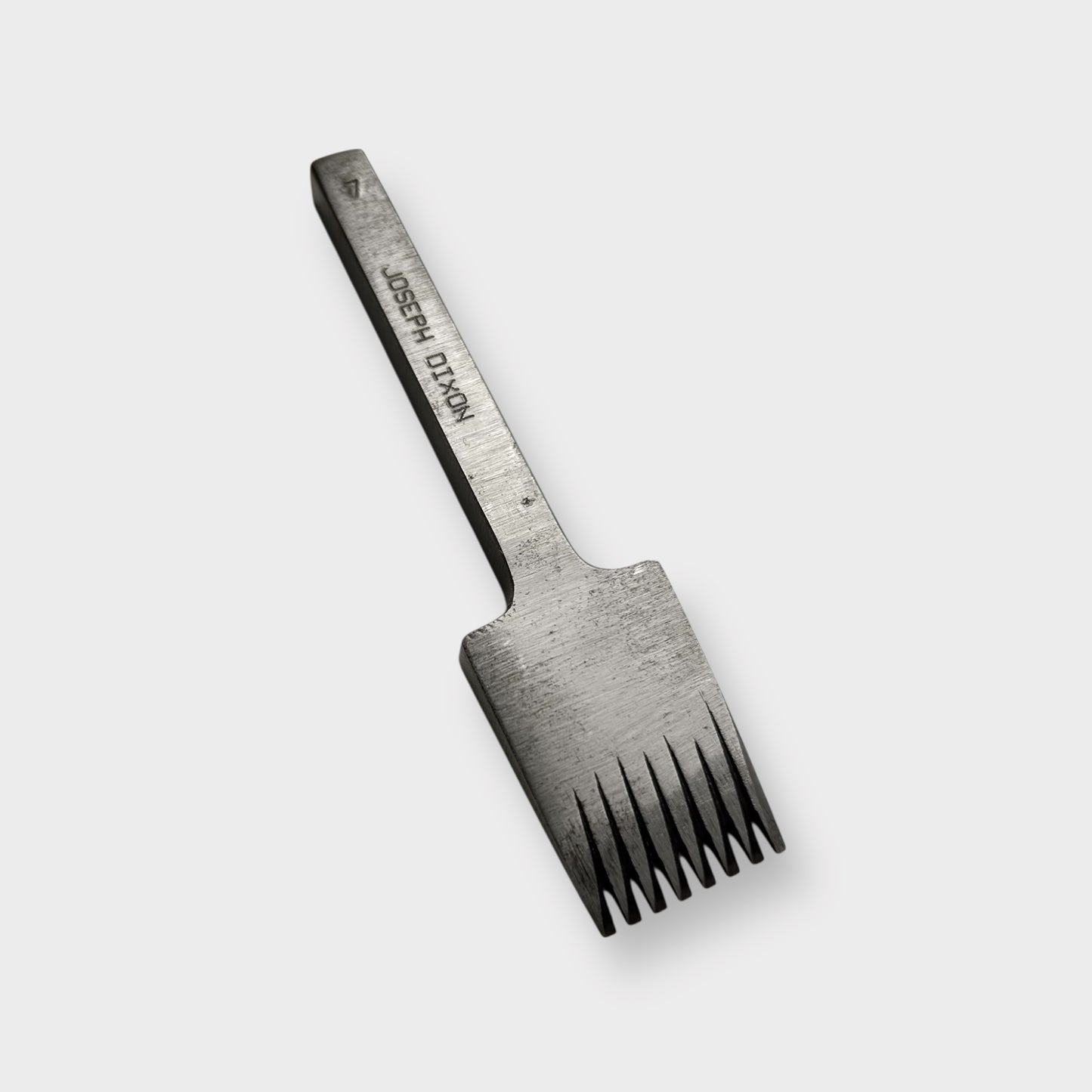 Metallic pricking iron leather tool with 'JOSEPH DIXON' engraving on a light gray background.