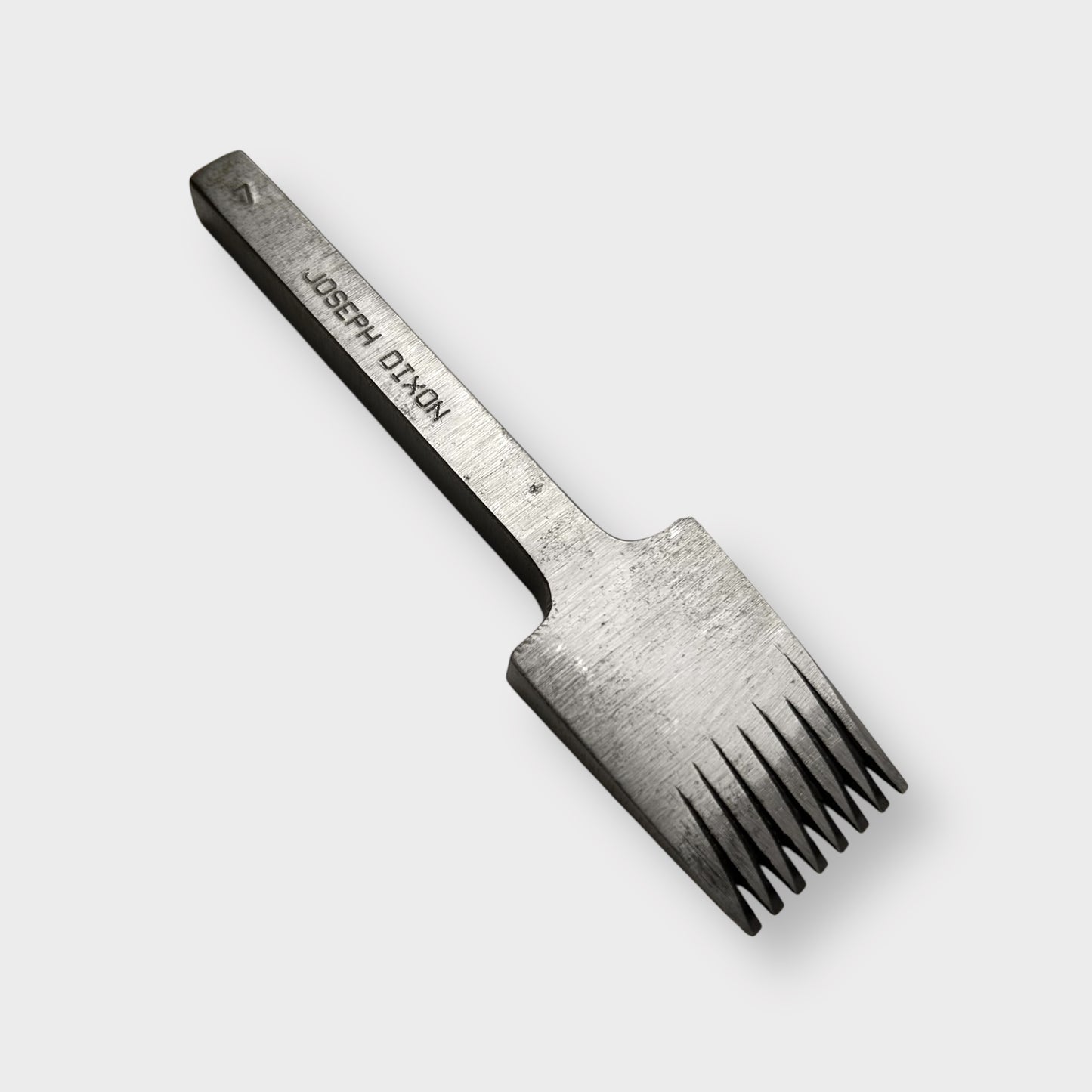 Metallic pricking iron leather tool with 'JOSEPH DIXON' engraving on a light gray background.