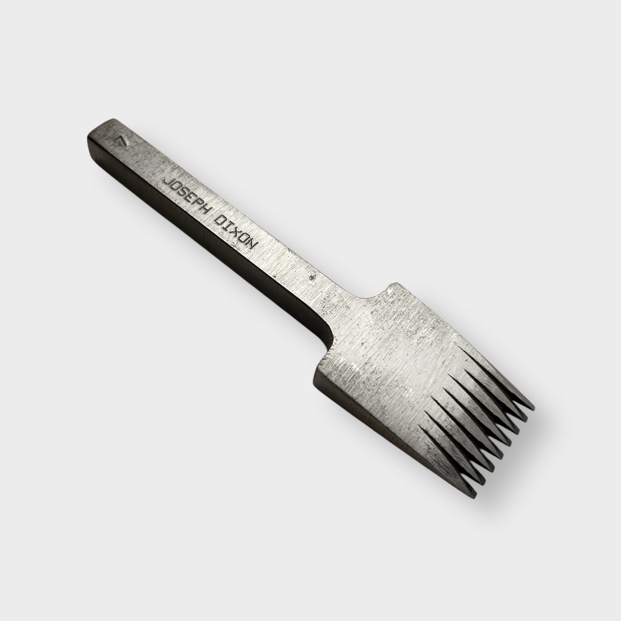 Metallic pricking iron leather tool with 'JOSEPH DIXON' engraving on a light gray background.