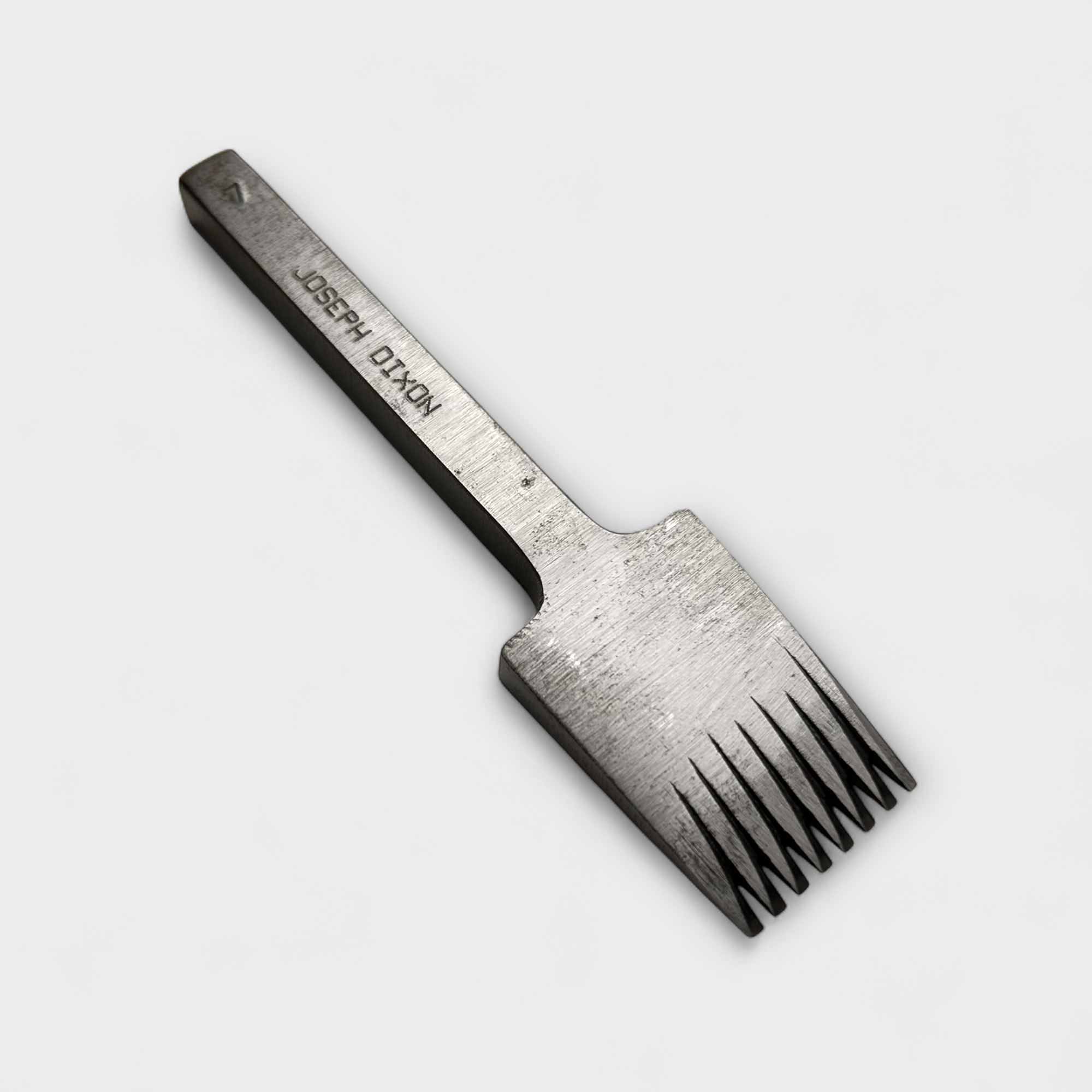 Metallic pricking iron leather tool with 'JOSEPH DIXON' engraving on a light gray background.