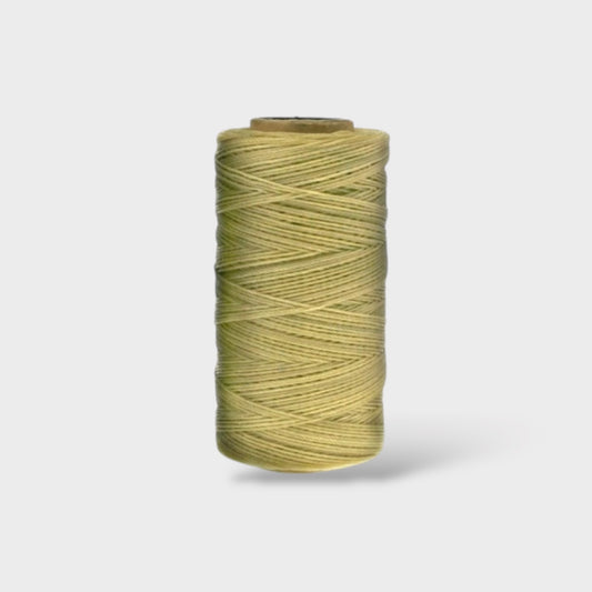 Spool of natural thread on a light gray background
