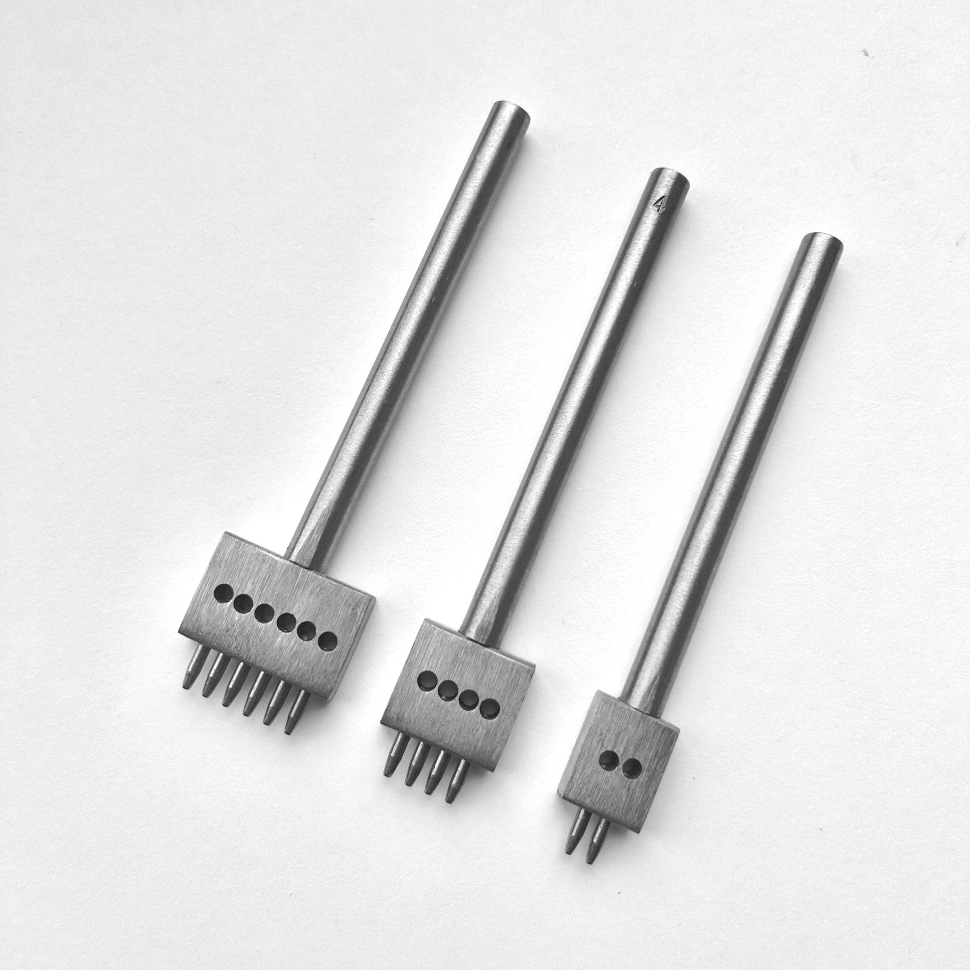 Three metal leather stitching punches with  on a white background