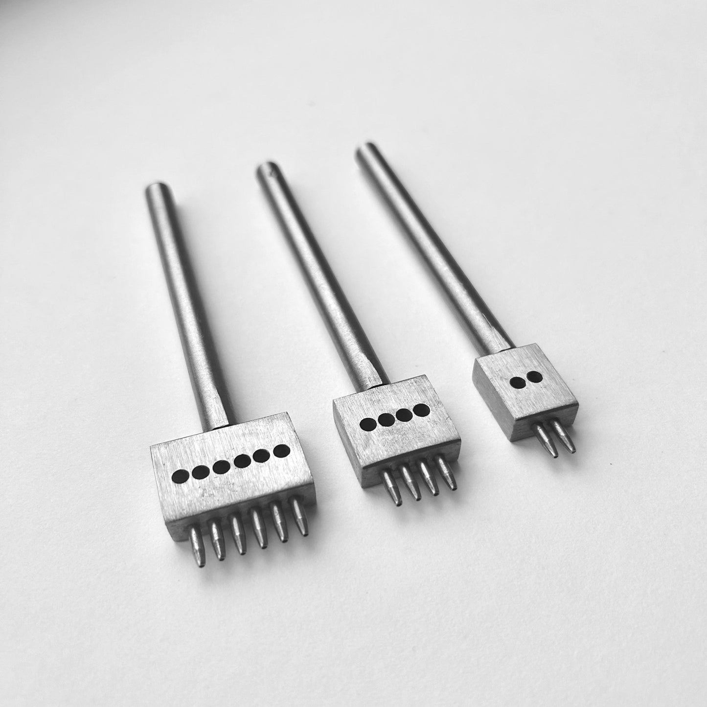 Three metal leather stitching punches with  on a white background