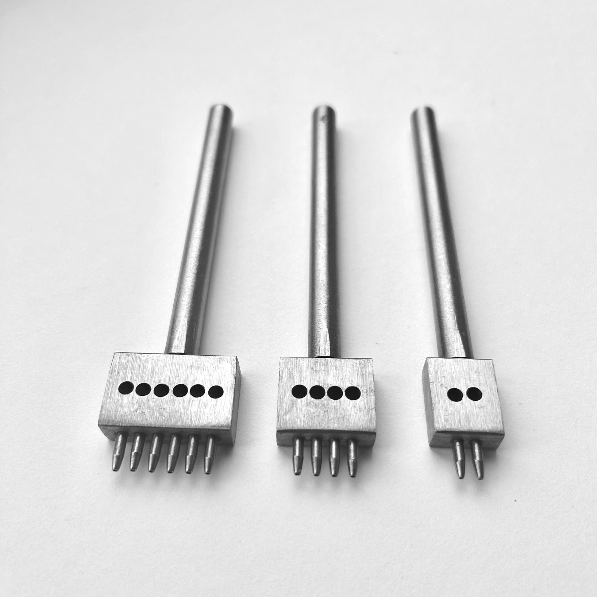 Three metal leather stitching punches with  on a white background