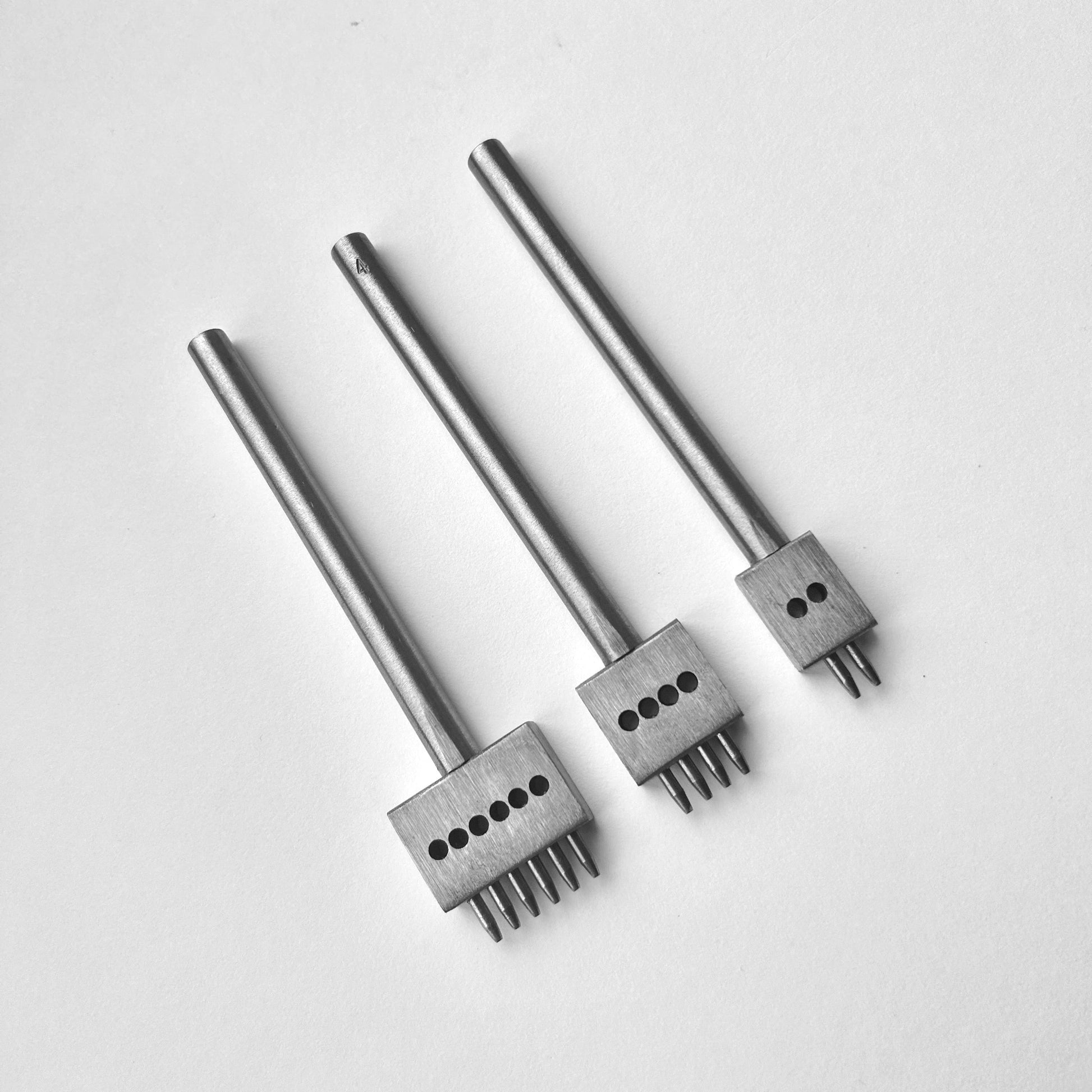 Three metal leather stitching punches with  on a white background
