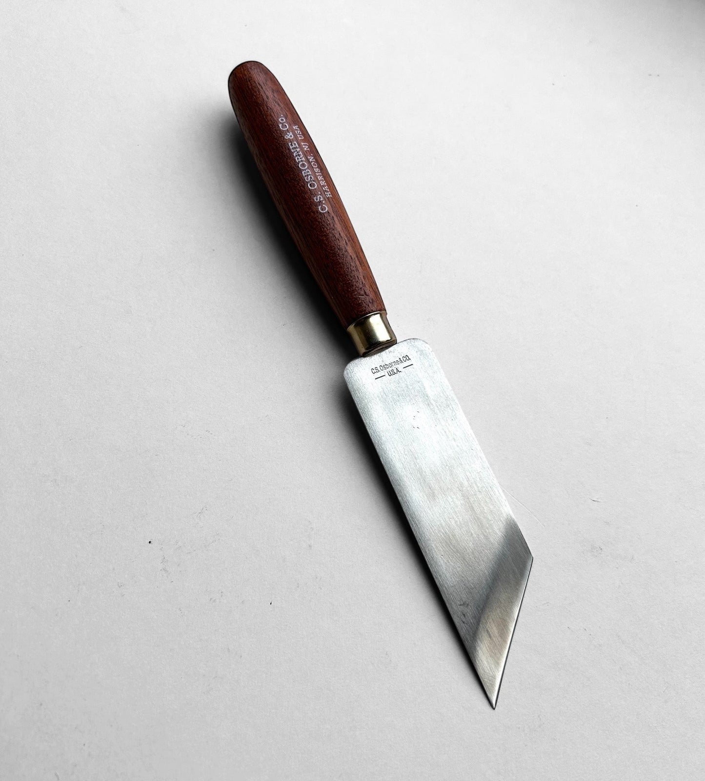 Knife with a brown handle on a light gray background