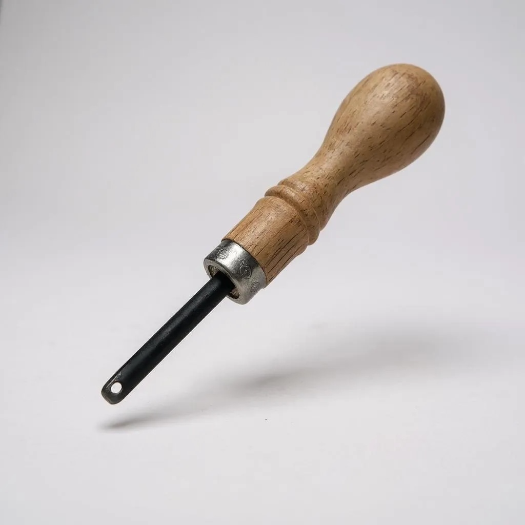 Wooden-handled leather stitch groover tool on a white background