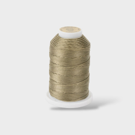 Spool of beige thread on a white background