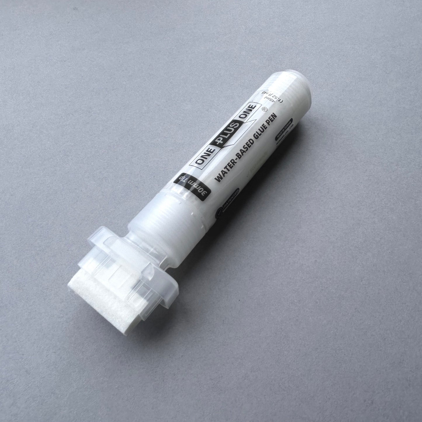 White water-based glue pen on a gray background
