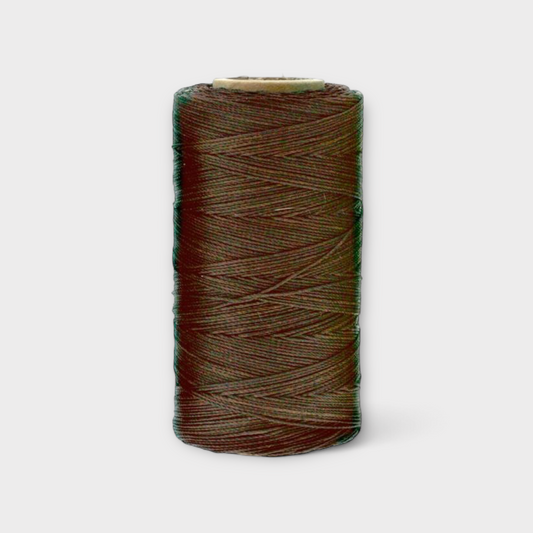 Spool of brown thread on a light gray background