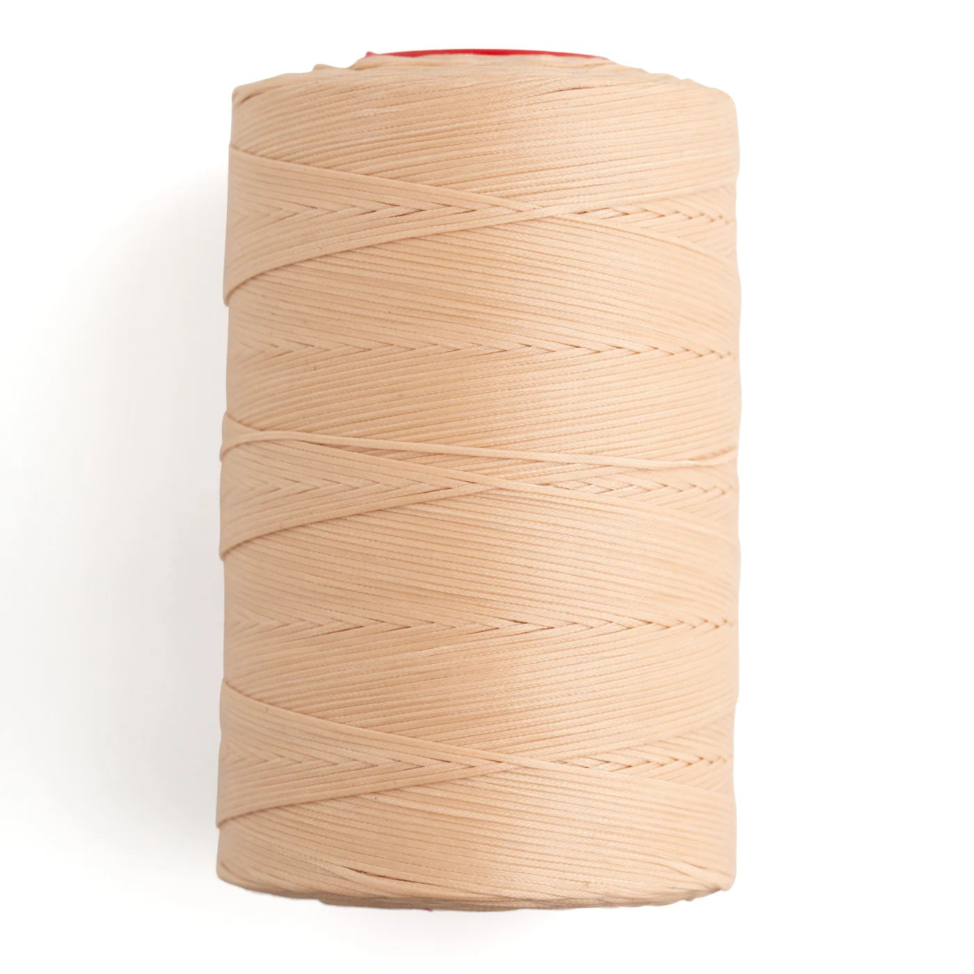 Spool of beige thread for hand stitching leather on a white background