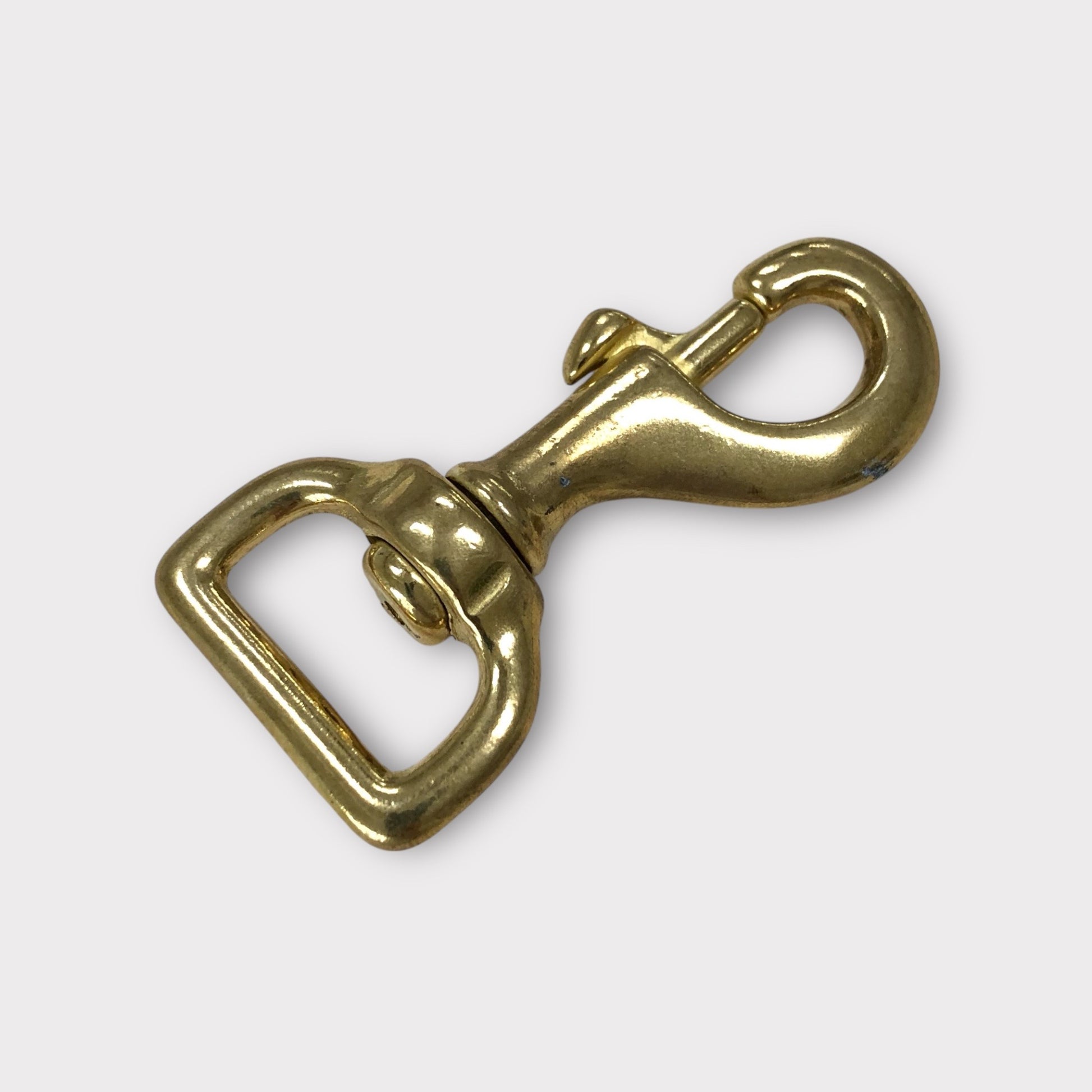 Gold metal trigger hook clasp on a white background