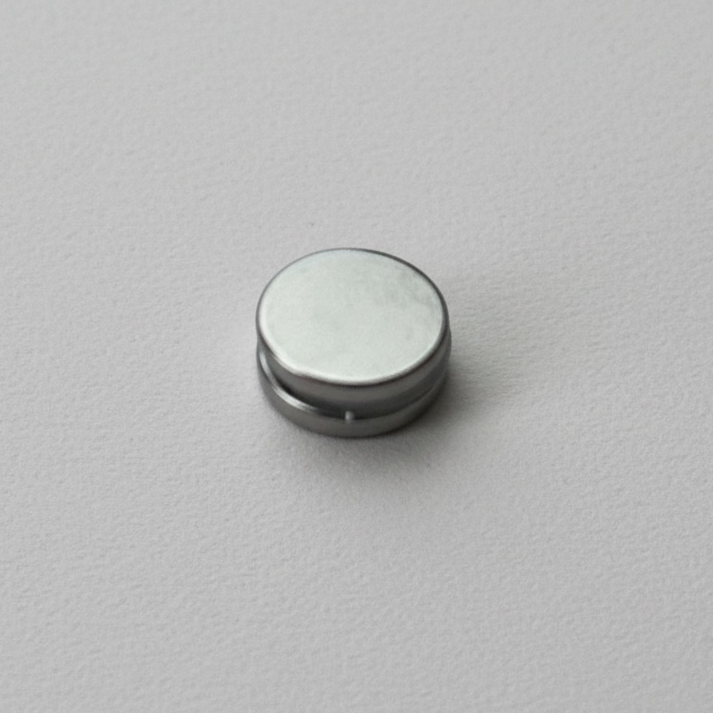 Magnetic button disc fastener on a grey background