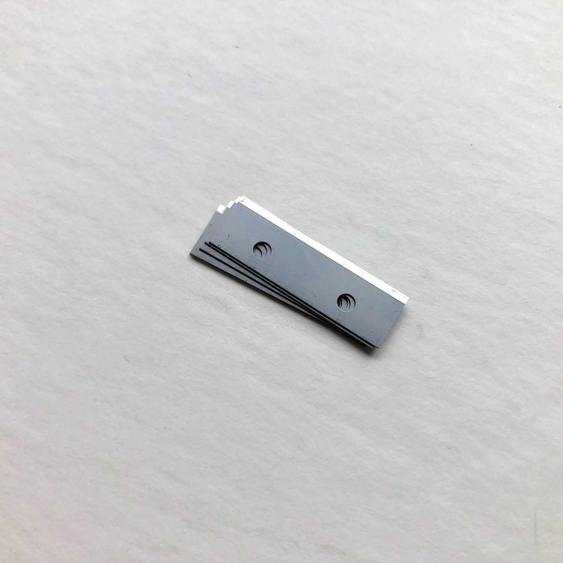 Replacement blades for leather strap cutter set on white background.