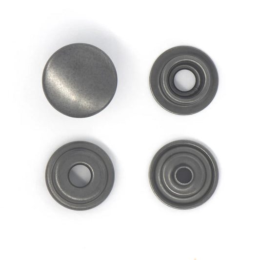Four metallic popper snaps on a white background