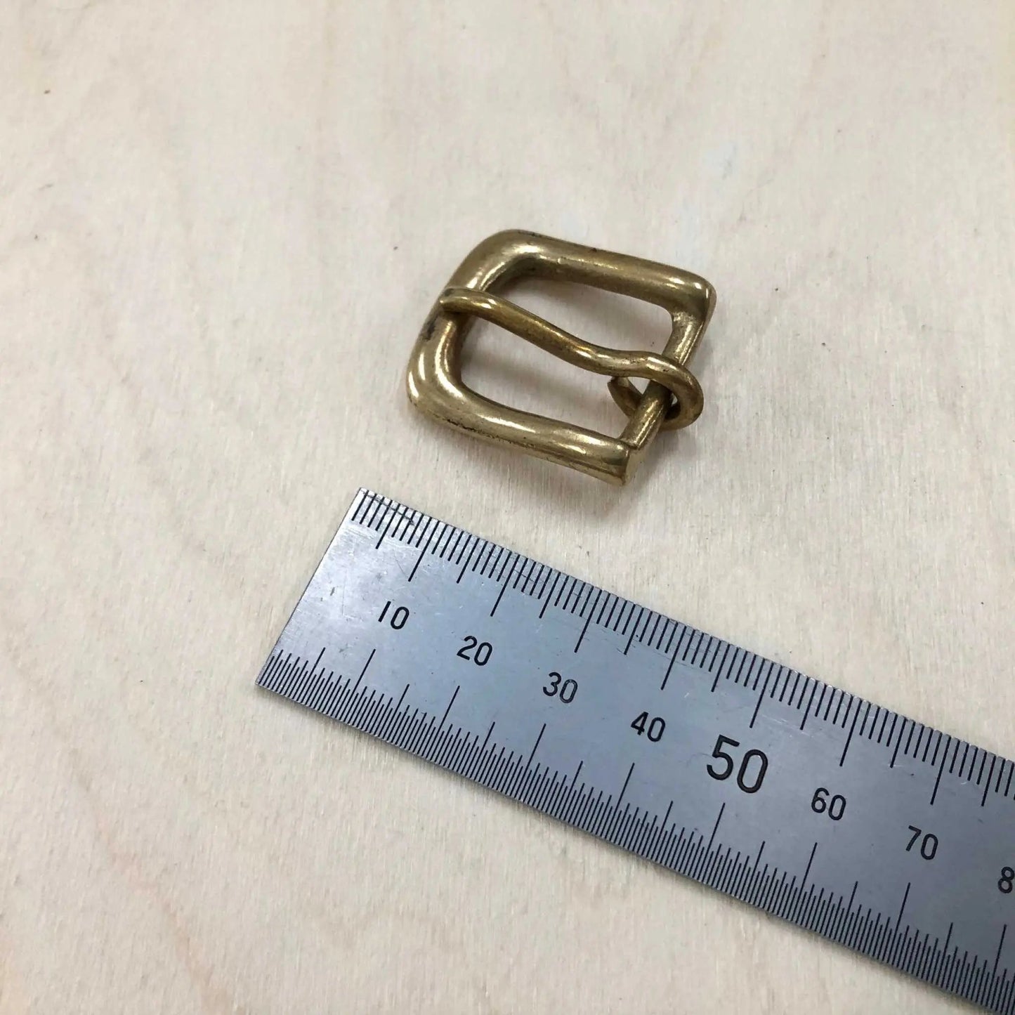 Solid Brass Buckle with Rounded Frame and Pin, shown with measuring tape for size reference.