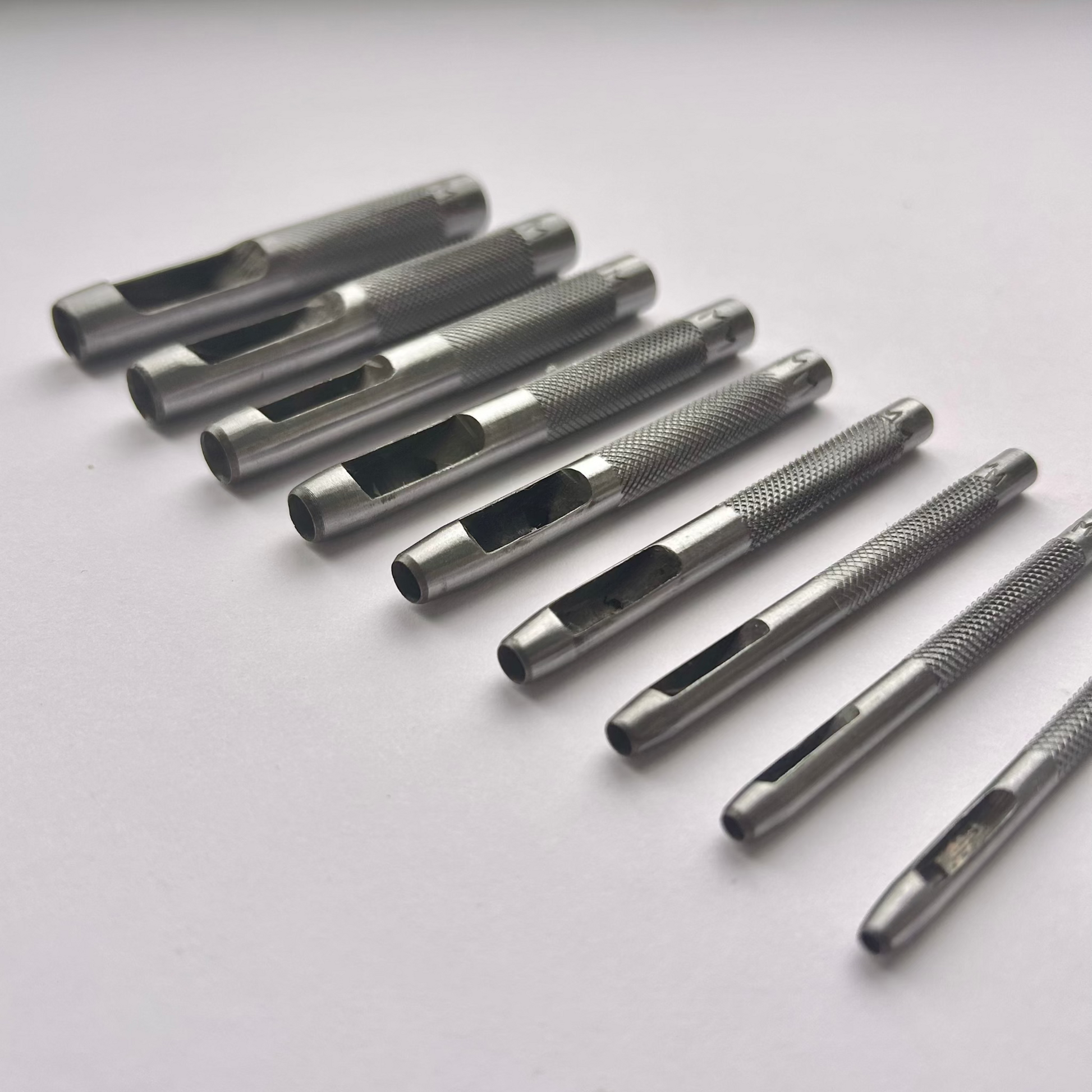 Set of metal leather drive punch tools on a grey background