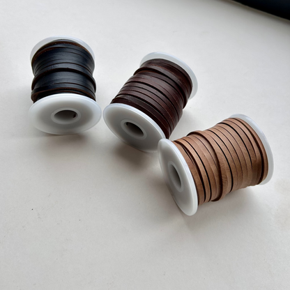Spools of Horween Leather Thonging Lace Brown, Black and Natural on a white background