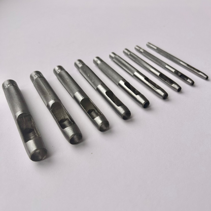 Set of metal leather drive punch tools on a grey background