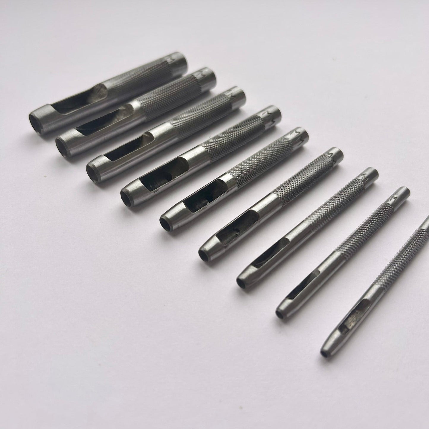 Set of metal leather drive punch tools on a grey background