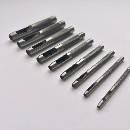 Set of metal leather drive punch tools on a grey background